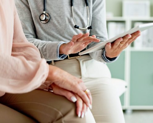 Doctor explaining info on a piece of paper to a patient